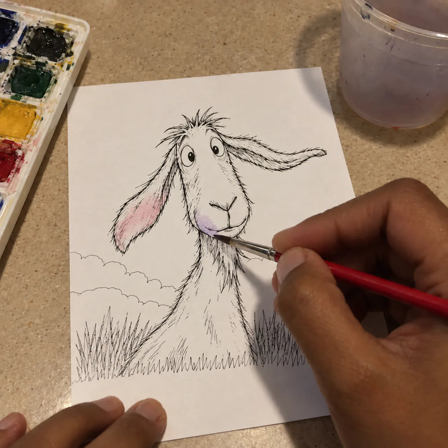Goat coloring page at the start of watercolor painting, with a hand holding a brush.