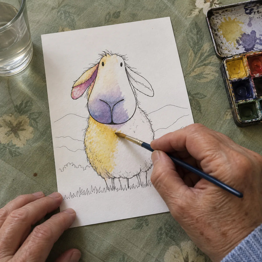 Sheep coloring page half painted, with white outline areas and a hand holding a brush.